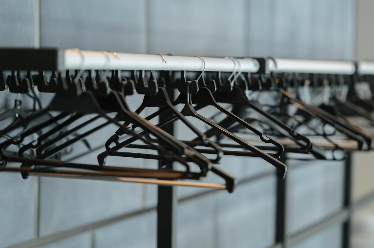 Empty clothes hangers are seen on a retail rack. (Adobe Stock Photo)