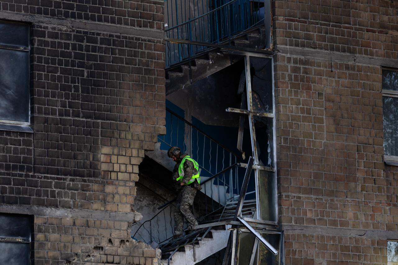 A police officer walks down the stairs searching for drone components that did not explode at a damaged school following a drone strike in Kyiv on October 1, 2026. (AFP Photo)