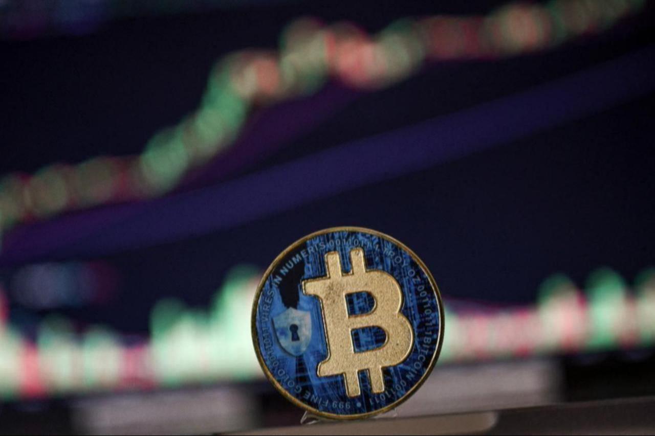 Photo illustration shows a coin imitation of the Bitcoin cryptocurrency arranged beside a screen displaying a trading chart, Nov. 22, 2024. (AFP Photo)