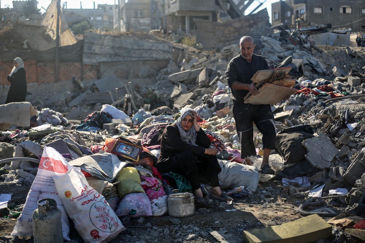 A woman sits with belongings amid the rubble of a house destroyed in an Israeli strike in the Bureij refugee camp on Oct. 30, 2026. (AFP Photo)