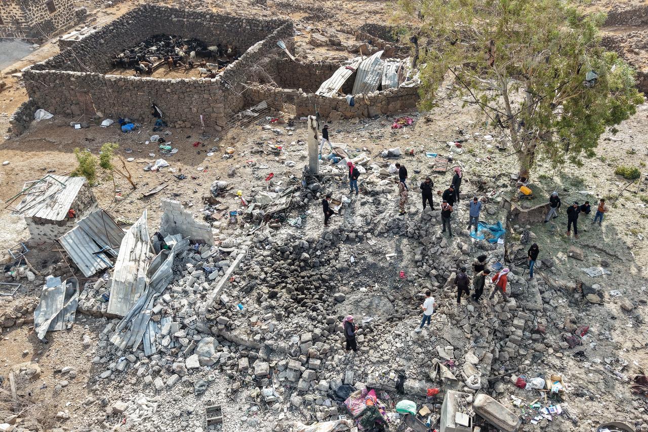 This picture shows an aerial view of people inspecting the damage at a site targeted by airstrikes, carried out the night before by Jordan on the village of Al-Taf in the Al-Lajat region, located in the northeastern countryside of Daraa, on October 27, 2026. (AFP Photo)