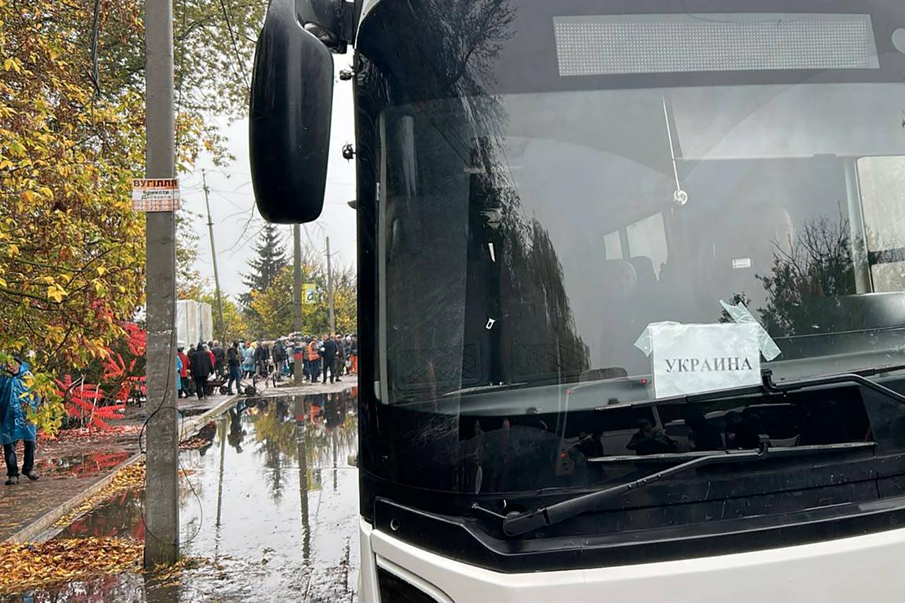 In this handout photograph posted on the official Telegram channel of Ukrainian politician David Arakhamia on October 30, 2026, local residents wait next to buses ahead of their evacuation in Oleshky, Kherson region. (Photo by Handout / TELEGRAM / @David_Arakhamia / AFP)