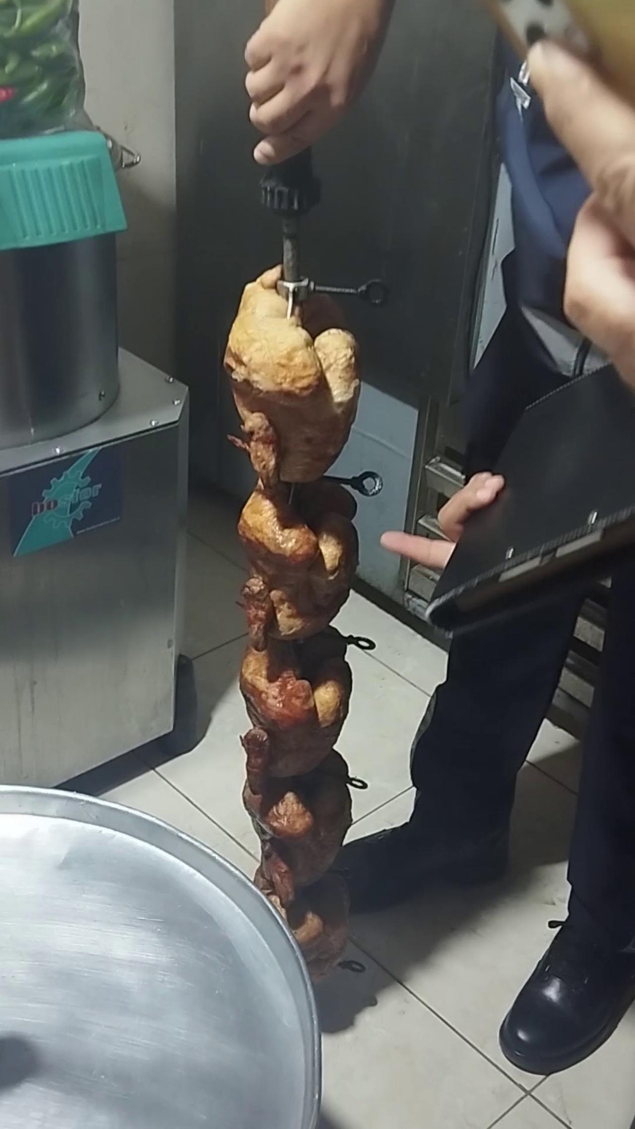 Cooked chickens are displayed on a vertical roasting skewer during a municipal food safety inspection at a restaurant in Kirikhan, Hatay, Türkiye. (IHA Photo)