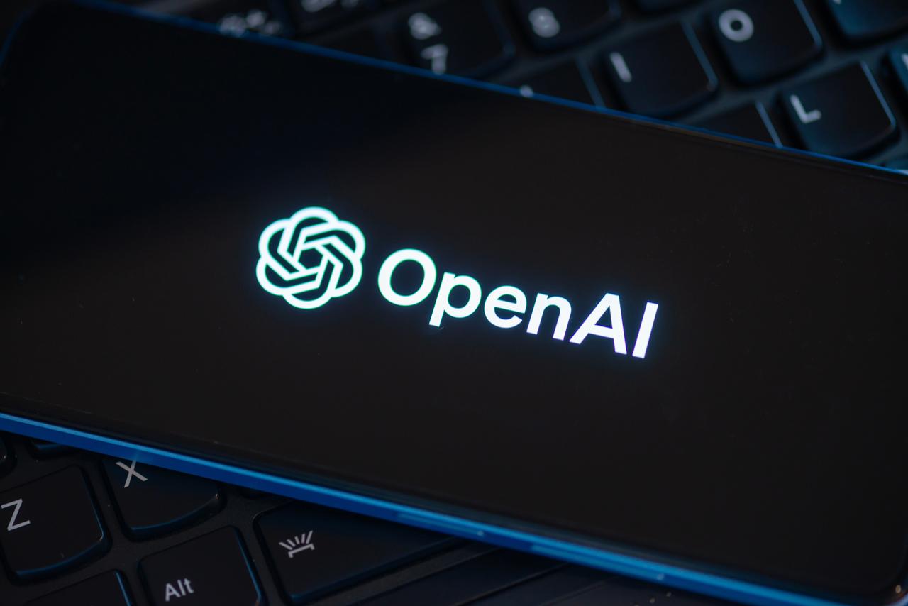 Photo shows hand pointing at SearchGPT page seen on the smartphone and official OpenAI company logo on background, accessed on Oct. 4, 2026. (Adobe Stock Photo)