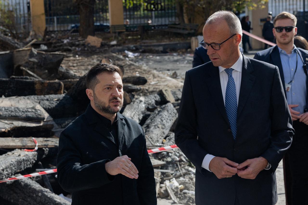Ukraine's President Volodymyr Zelensky (L) and German Chancellor Friedrich Merz (R) visit damaged building of the Ukrainian Academy of Science in Kyiv on October 4, 2026. (AFP Photo)
