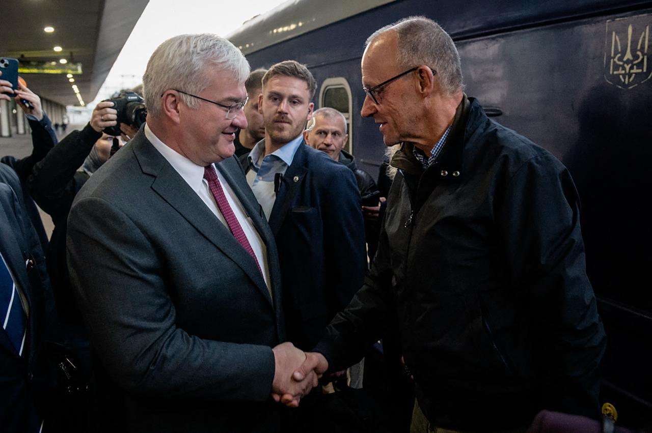 In this handout photograph taken and released by the Ukrainian Foreign Ministry on October 4, 2026, Ukraine's Foreign Affairs Minister Andrii Sybiha (L) greets German Chancellor Friedrich Merz (R) at a railway station in Kyiv, amid the Russian invasion of Ukraine. (Photo by Handout / Ukrainian Foreign Ministry / AFP)