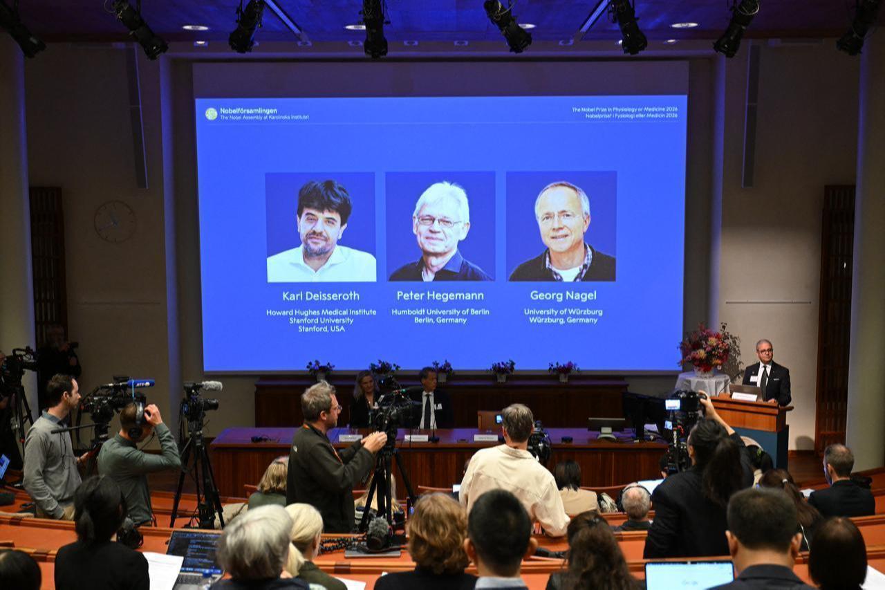 Neuroscience professor Abdel El Manira speaks as portraits of the 2026 Nobel Prize in Physiology or Medicine winners appear on a screen at the Karolinska Institute. (AFP Photo)