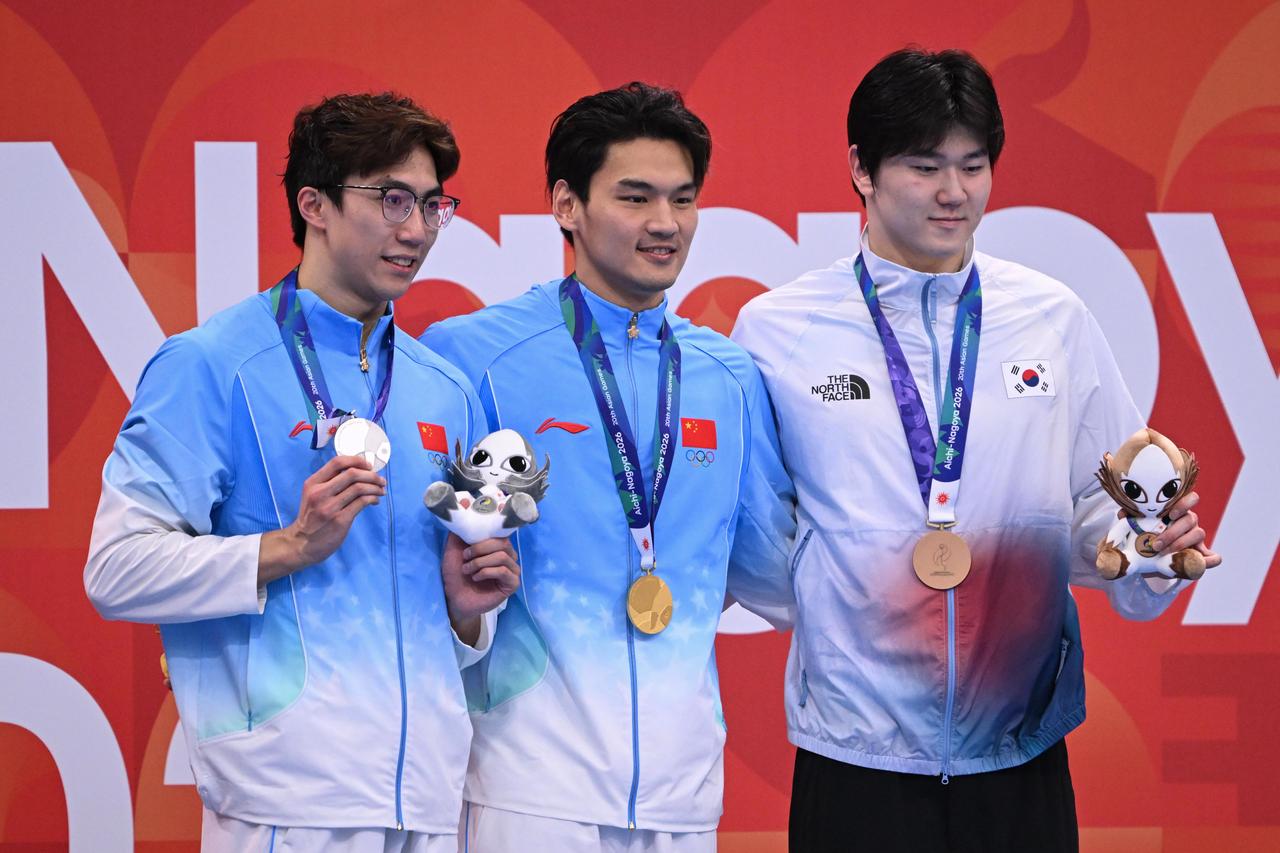 China’s Wang Zicheng, left, and Xu Jiayu, center, pose with South Korea’s Yoon Ji-hwan after winning silver, gold and bronze, respectively, in the men’s 50-meter backstroke at the 20th Asian Games at Tokyo Aquatics Centre in Tokyo, Japan, Sept. 21, 2026. (AA Photo)