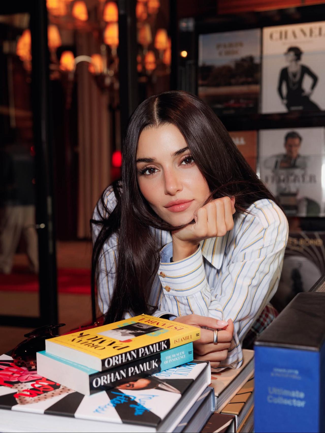 Hande Ercel poses beside copies of Orhan Pamuk's books during her Valentino appearance, with the author's works becoming a prominent detail of the photo shoot. (Photo via Instagram/@handemiyy)