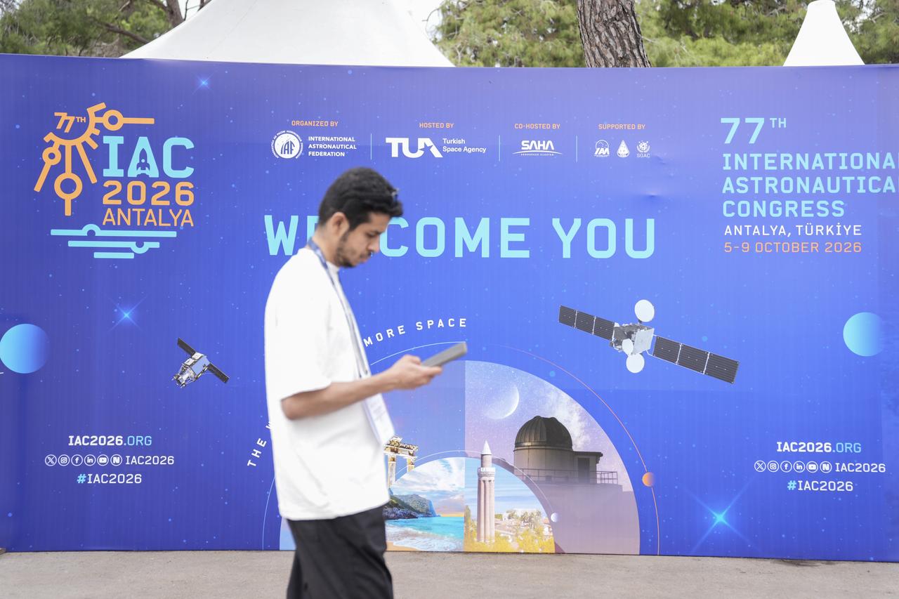 A visitor walks past a welcome display for the 77th International Astronautical Congress, scheduled for Oct. 5-9, in Antalya, Türkiye, Oct. 4, 2026. (AA Photo)