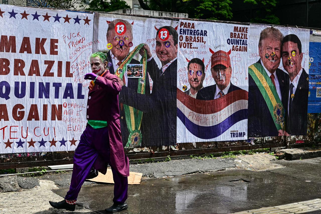 A man dressed as the Joker walks past a wall with images of US President Donald Trump and Brazil's right-wing senator and presidential candidate for the Liberal Party (PL) Flavio Bolsonaro during the presidential election on Avenida Paulista in Sao Paulo, Brazil, on October 4, 2026. (AFP photo)