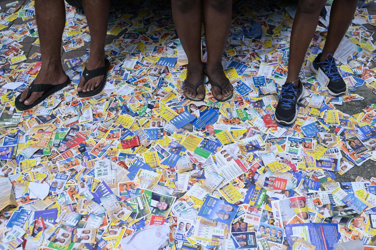 People step on political flyers lying in the street at Cidade de Deus, in southwest Rio de Janeiro, Brazil, on the day of the presidential election, on October 4, 2026. (AFP photo)