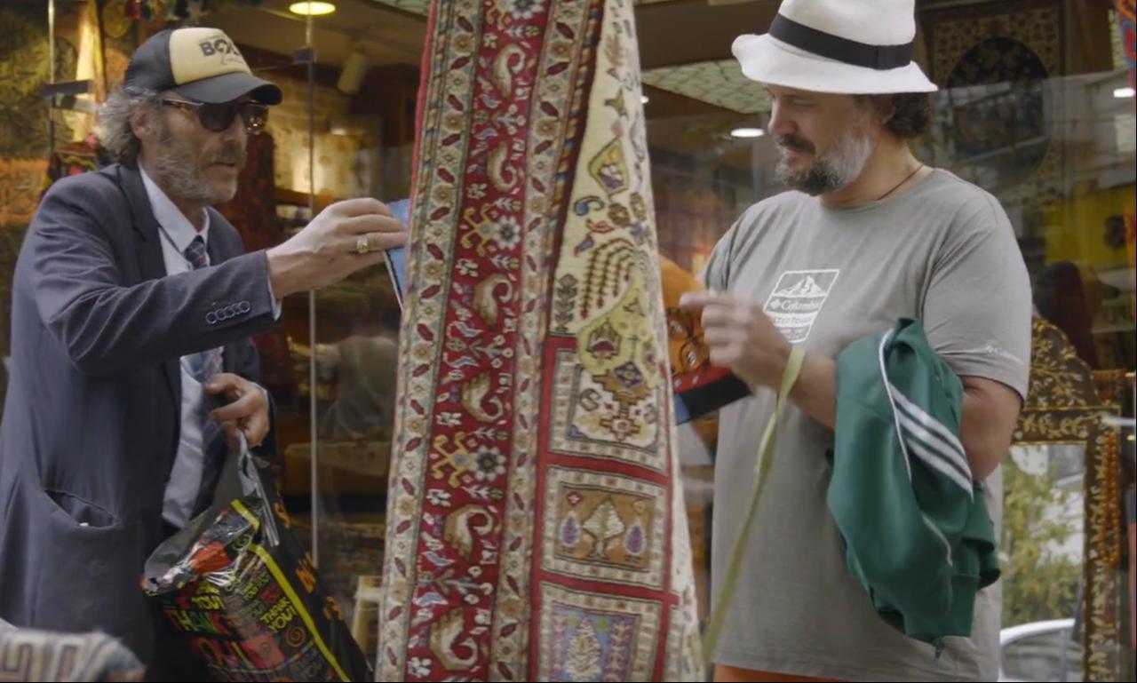 The protagonists browse carpets and souvenirs in Istanbul as their cycling journey reaches Türkiye in "A Bicyclette!." (Image via M.E.S. Productions, F Comme Film)