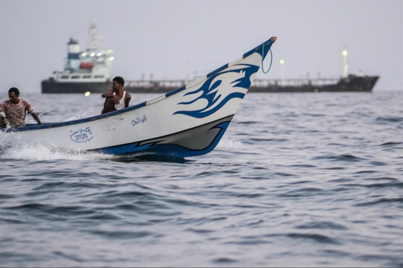 Fishermen's motorboat passes a commercial vessel anchored off Yemen's coast at Bab al-Mandeb, in the strait connecting the Red Sea with the Gulf of Aden and the Indian Ocean on September 12, 2026. (AFP Photo)