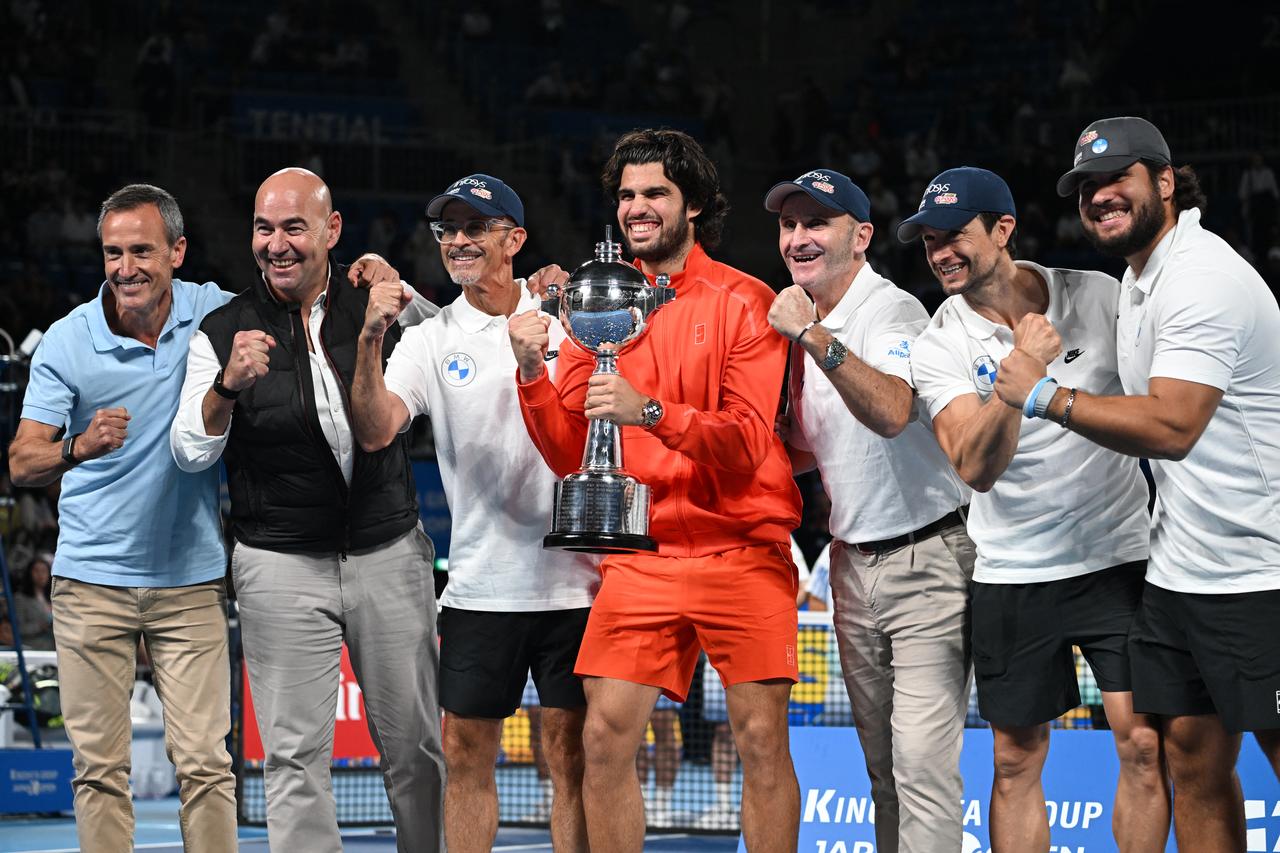 Spain's Carlos Alcaraz (C) holds the trophy as he celebrates with his team after beating the Czech Republic's Jiri Lehecka in the men's singles final during the Japan Open tennis tournament at the Ariake Tennis Forest Park in Tokyo on Oct. 6, 2026. (AFP Photo)
