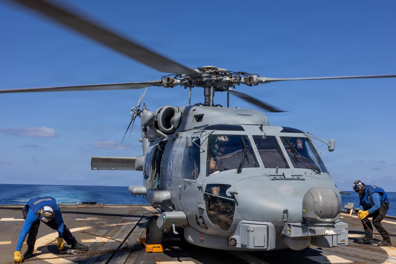 U.S. Navy Boatswain’s Mate removes chocks and chains from a U.S. Navy MH-60R Sea Hawk helicopter on the flight deck of the Arleigh Burke-class guided-missile destroyer USS Wayne E. Meyer (DDG 108) in the South China Sea, Sept. 30, 2026. (Photo via U.S. Navy)