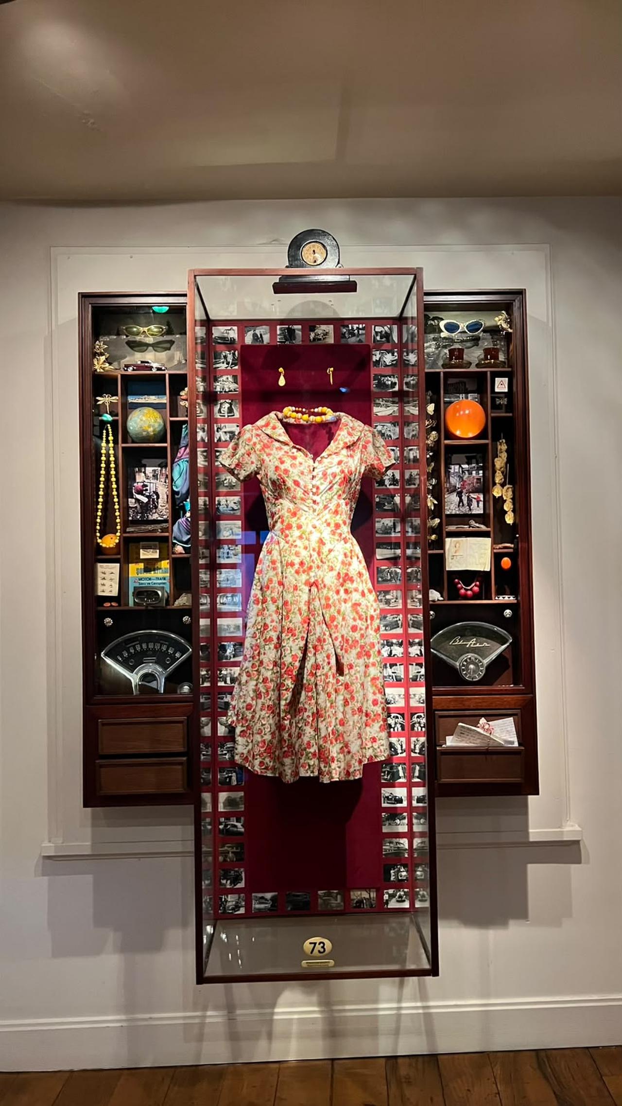 A floral dress hangs among photographs and everyday objects in a display at the Museum of Innocence. (Photo by Nour Dajani)