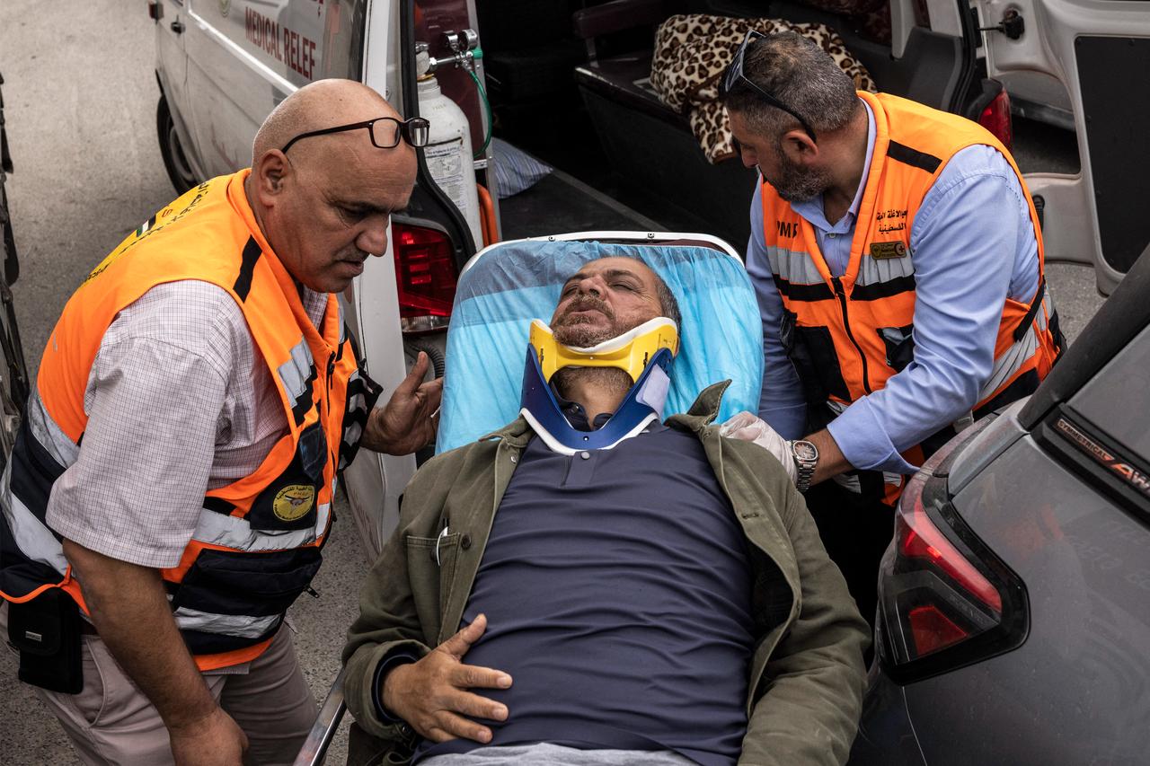 Agence France-Presse's (AFP) photographer Jaafar Ashtiyeh is carried by Palestinian first responders to seek medical assistance after being beaten by several Israelis in Aqraba in the Israeli-occupied West Bank on October 6, 2026. (AFP Photo)