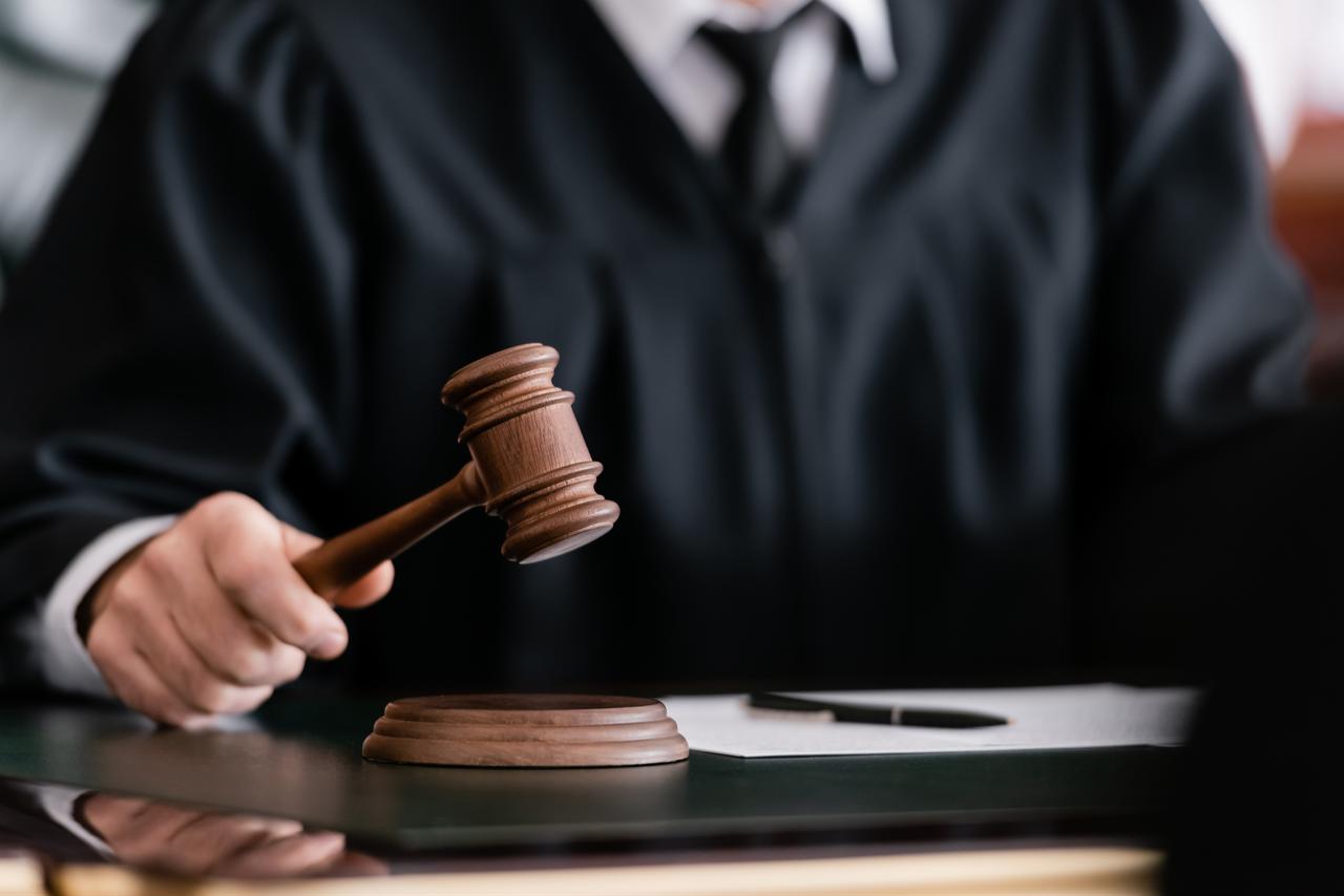 A judge holds a gavel during court proceedings in an illustrative image. (Adobe Stock Photo)