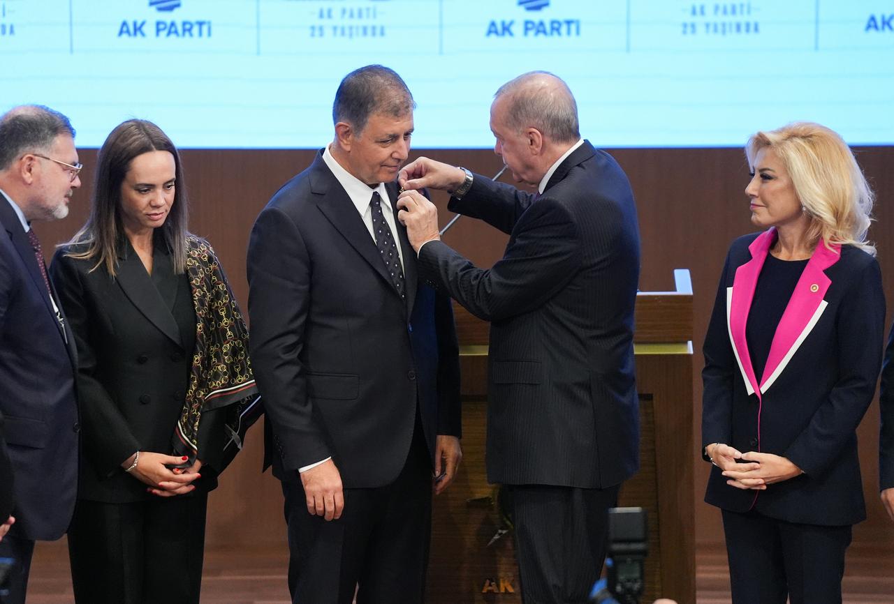 Turkish President and Leader of the Justice and Development (AK) Party Recep Tayyip Erdogan (2nd R) pins an AK Party badge on Izmir Metropolitan Municipality Mayor Cemil Tugay (3rd L), who joined the party, during the Legislative Year Opening Meeting with AK Party lawmakers at the AK Party Congress Center in Ankara, Türkiye, on Oct. 7, 2026. (AA Photo)