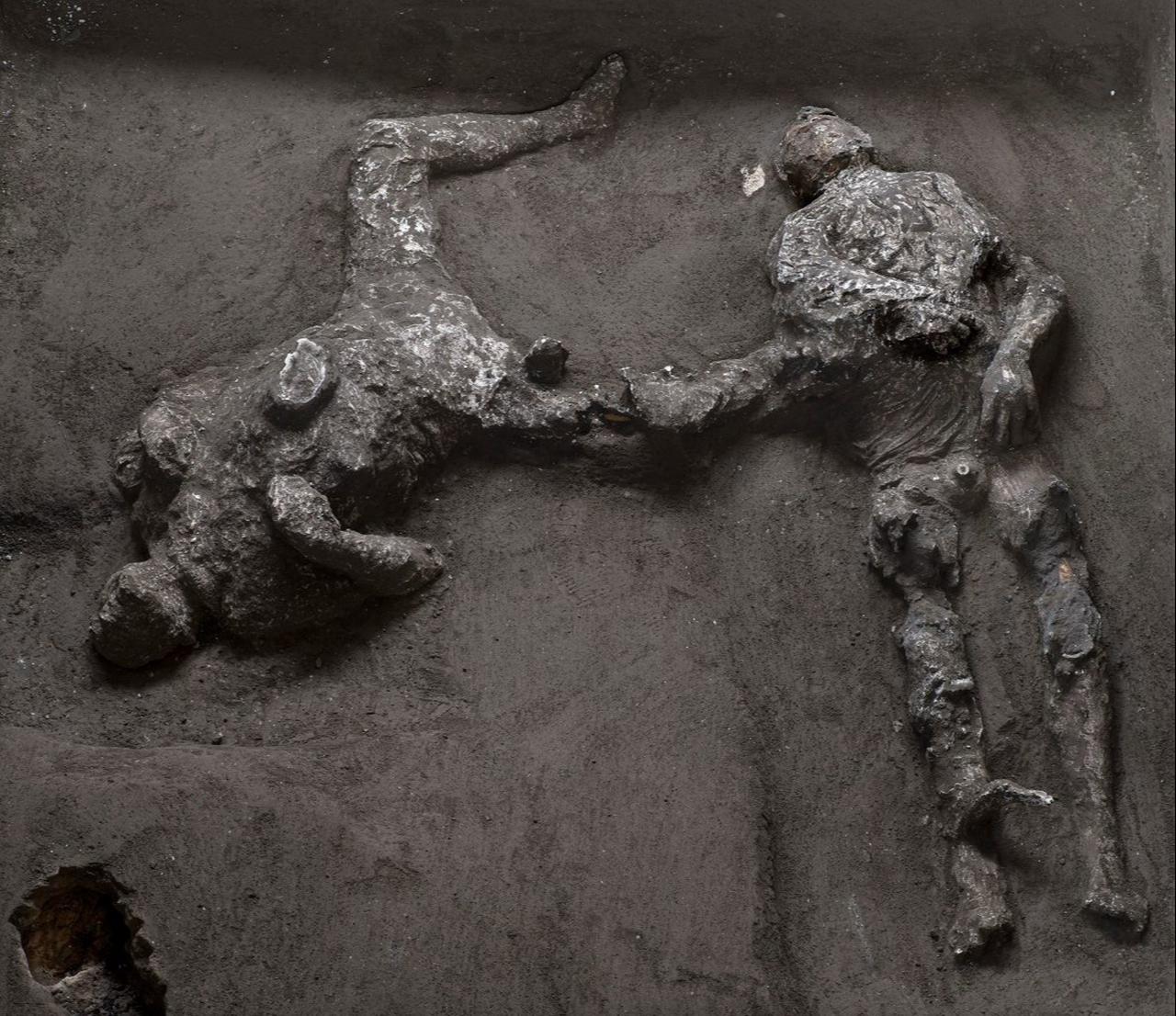 Two victims uncovered at Pompeii are preserved in dark casts that record their final positions during the A.D. 79 disaster. (Photo via The Archaeological Park of Pompeii)