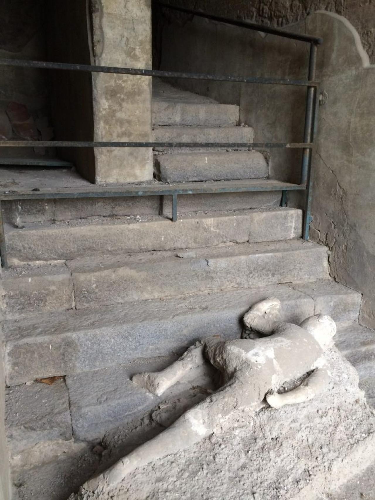 A plaster cast of a victim lies beside a staircase at Pompeii, preserving the person's final position during the A.D. 79 eruption. (Photo via The Archaeological Park of Pompeii)