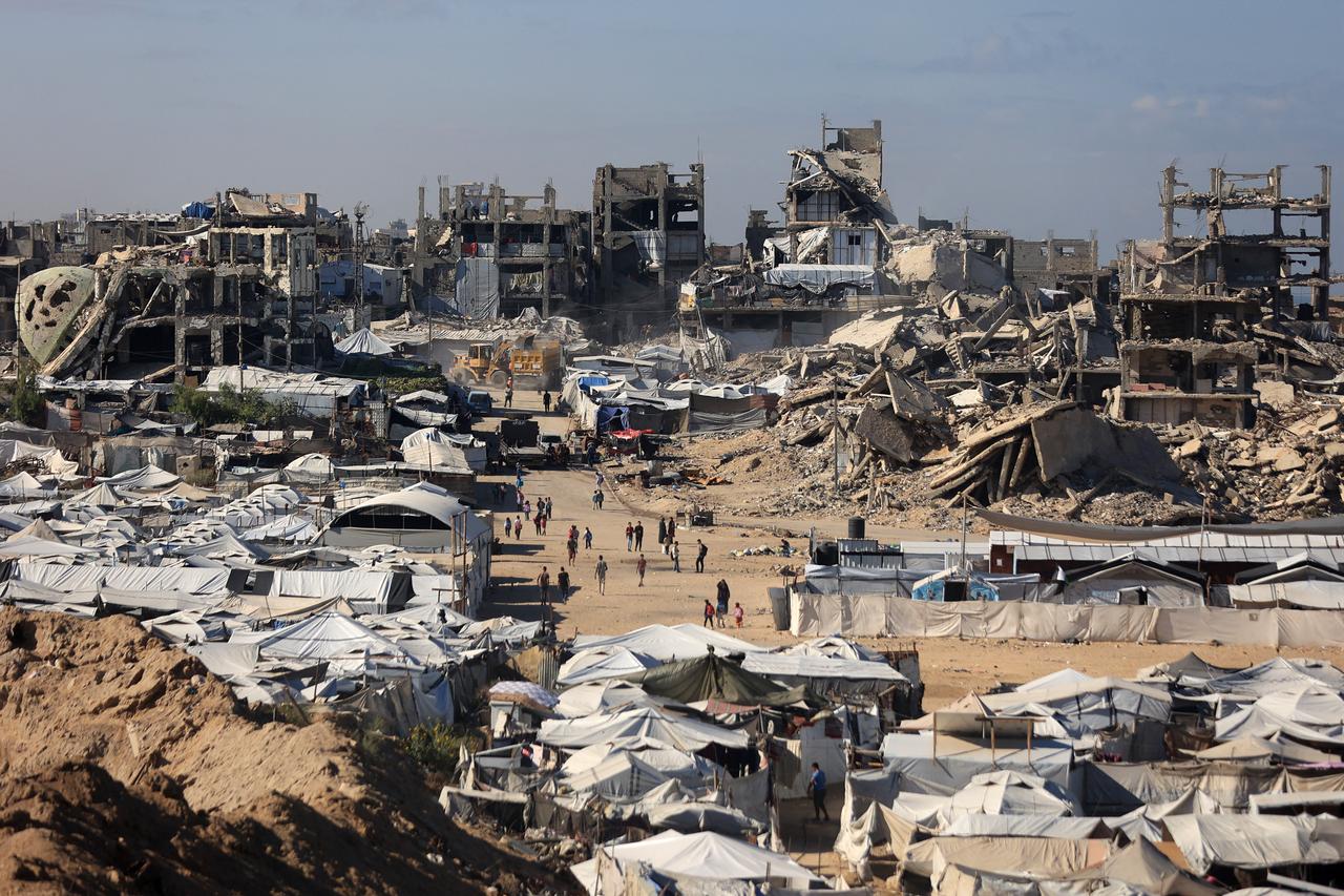 Displaced Palestinians walk amid their temporary tents near destroyed buildings in Gaza City on October 7, 2026. (AFP Photo)