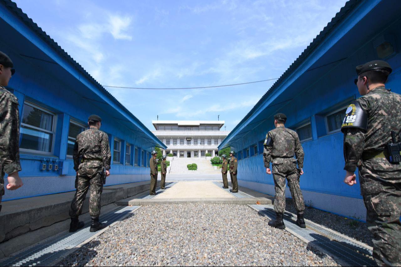 South Korean soldiers (front) and North Korean soldiers (rear) stand guard before the military demarcation line on the each side of the truce village of Panmunjom in the Demilitarized zone (DMZ) dividing the two Koreas on April 26, 2018. (AFP Photo)