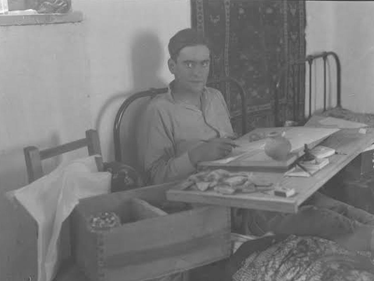 German archaeologist Hans Henning von der Osten examines archaeological finds while seated at a worktable during his research in Türkiye. (Photo courtesy of the Oriental Institute, University of Chicago)