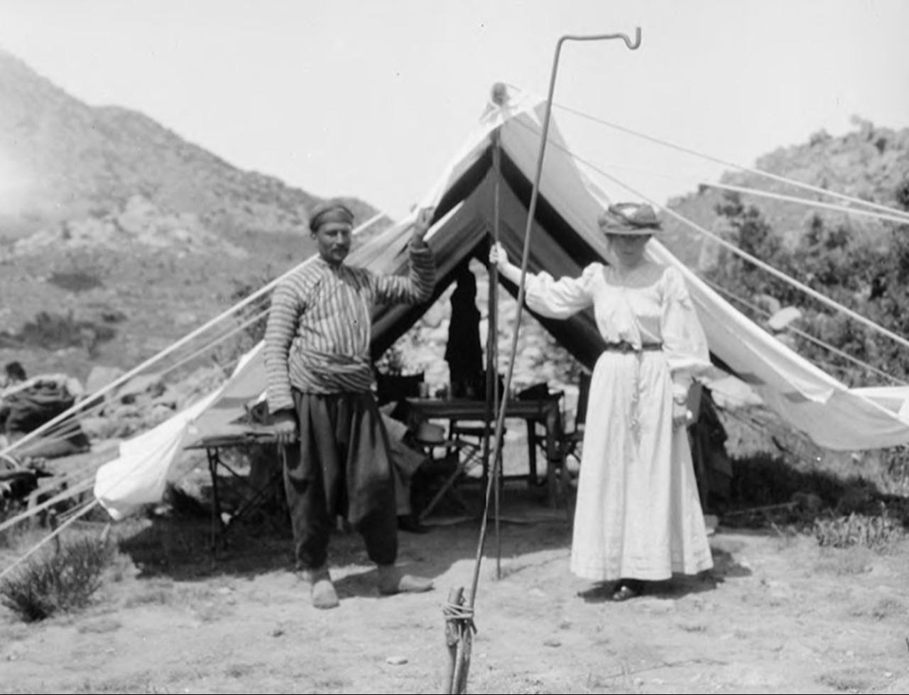 Gertrude Bell and Fattuh standing in front of a tent at camp, Türkiye, 1909. (Photo via Gertrude Bell Archive)