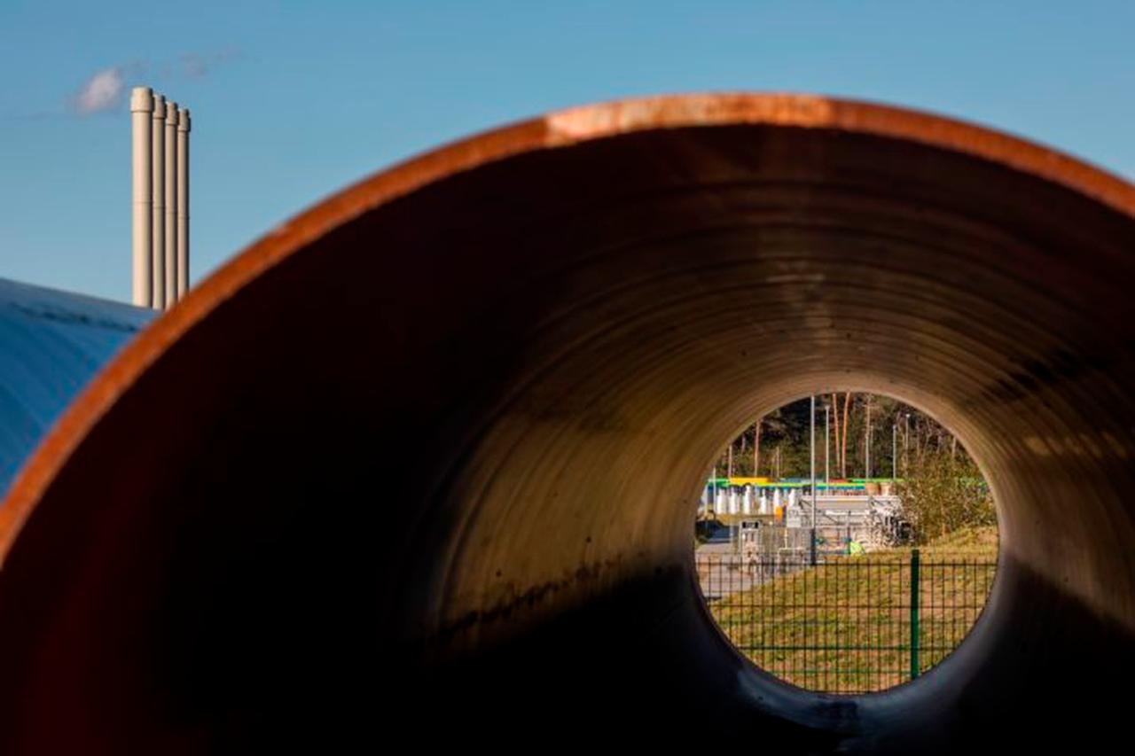 People working at the Nord Stream 2 gas line landfall facility in Lubmin, northeastern Germany, are seen through a metal pipe on September 7, 2020. (AFP Photo)