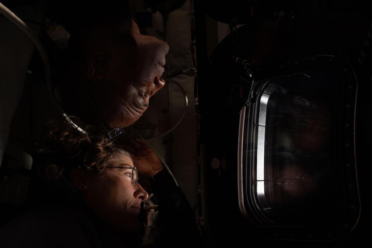 NASA astronauts Christina Koch (below) and Victor Glover (above) share a window inside the Orion spacecraft during the sixth day of the Artemis II mission. (NASA Photo)