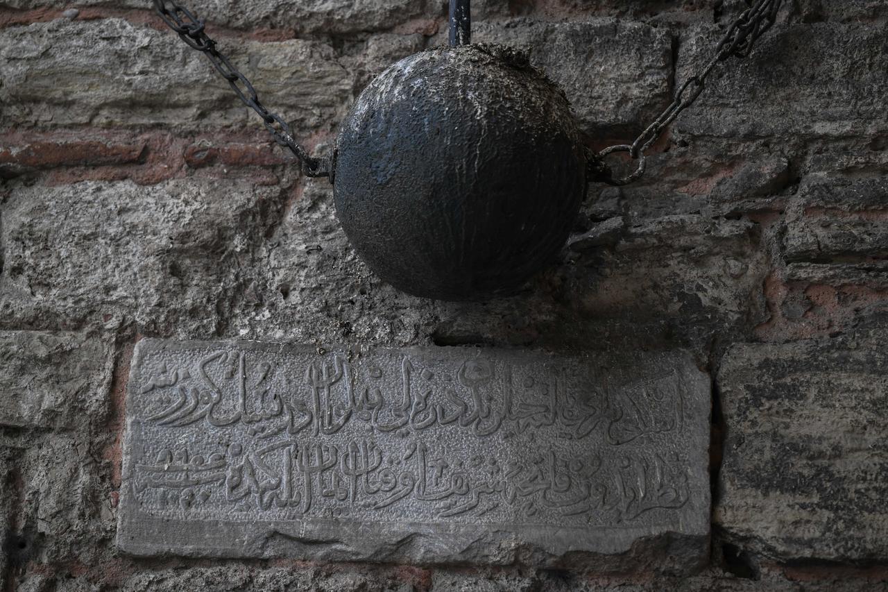 A close-up of a Bozdogan mace hanging on the wall at Silivrikapi above an Ottoman-era inscription on Oct. 8, 2026. (AA Photo)
