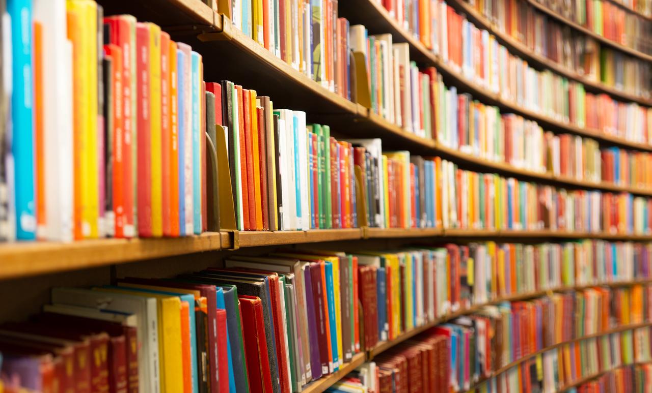 Rows of books line shelves in a library, illustrating access to published works and literary collections. (Adobe Stock Photo)