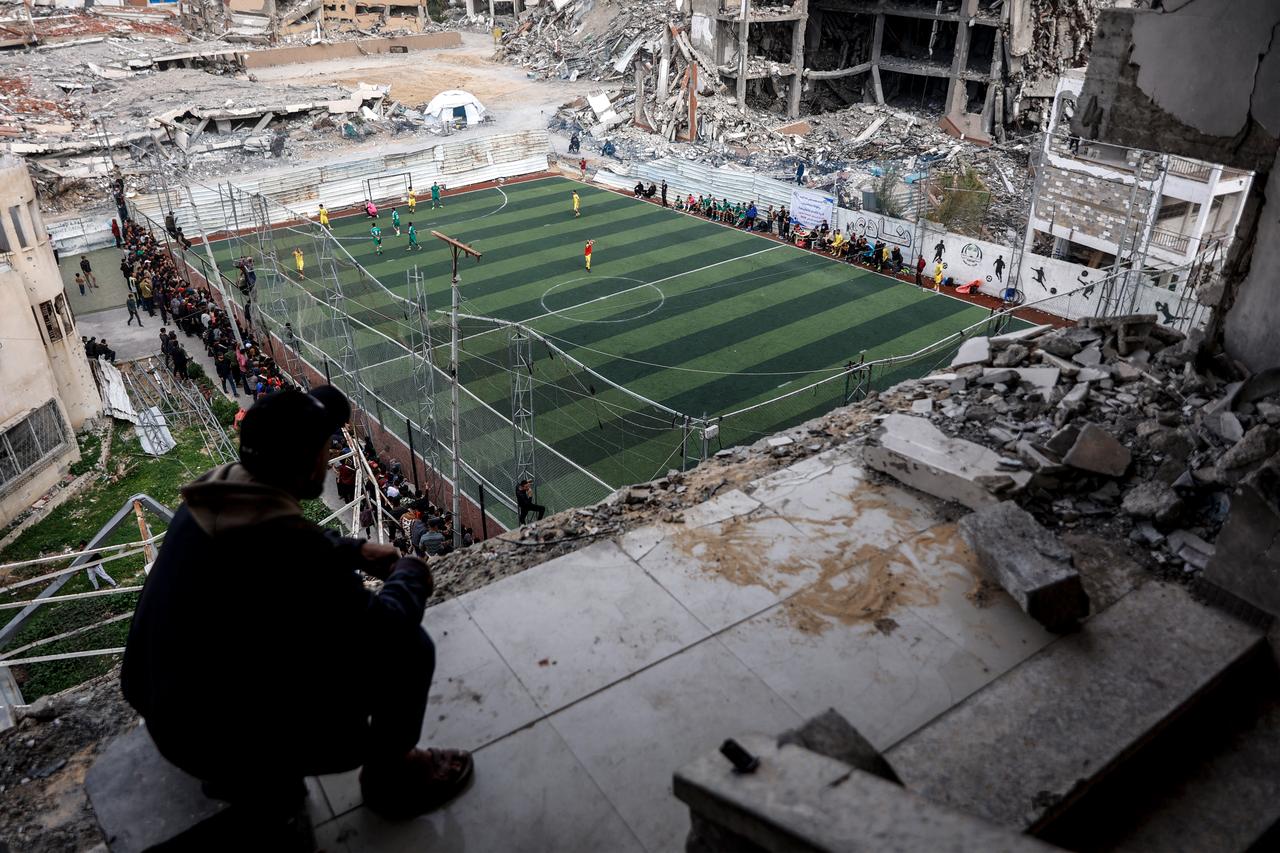 Palestinians watch a five-a-side football match amid the rubble of destroyed buildings in Gaza City on February 9, 2026. (AFP Photo)