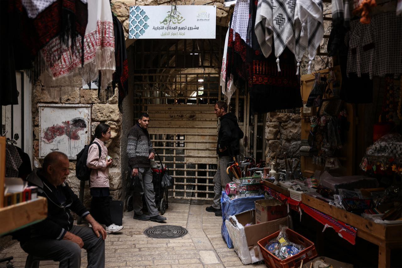 Palestinians wait for Israeli soldiers to allow them to cross through a gate to reach their homes in Hebron's Old City, in the Israeli-occupied West Bank, February 9, 2026. (AFP Photo)