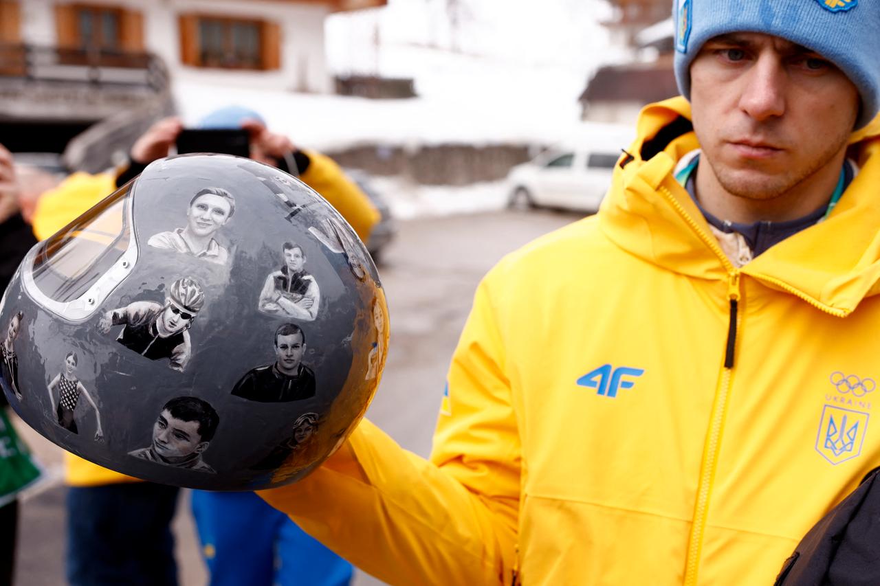Ukraine's skeleton racer Vladyslav Heraskevych holds his helmet, which depicts victims of his country's war with Russia, in Cortina d'Ampezzo on February 12, 2026. (AFP Photo)