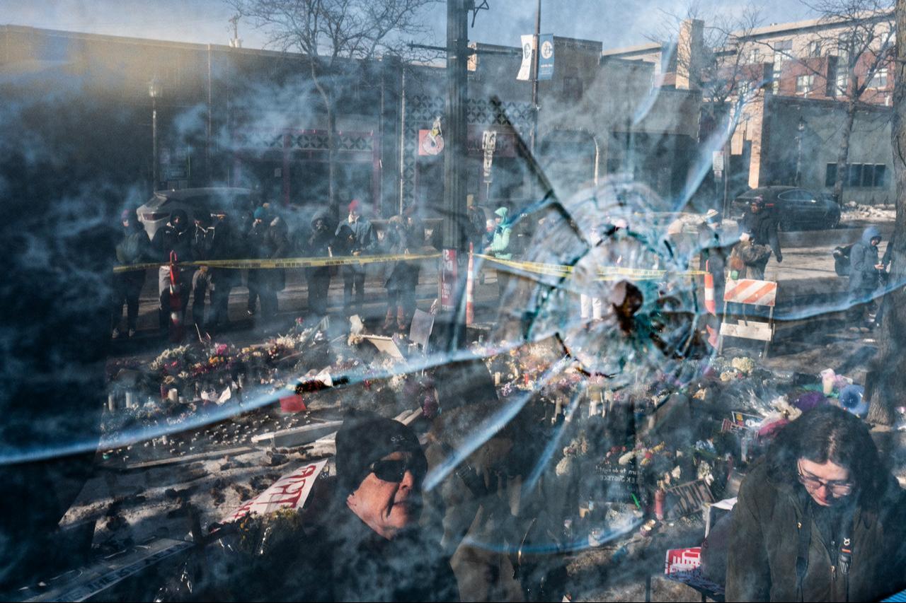 A gun shot perforation in a window pane can be seen in a window in front of a makeshift memorial for Alex Pretti on Jan. 26, 2026 in Minneapolis, United States. (AFP Photo)