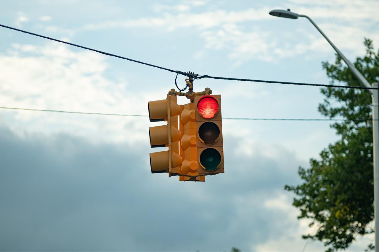 Red traffic light illuminated at an urban intersection. (Adobe Stock Photo)