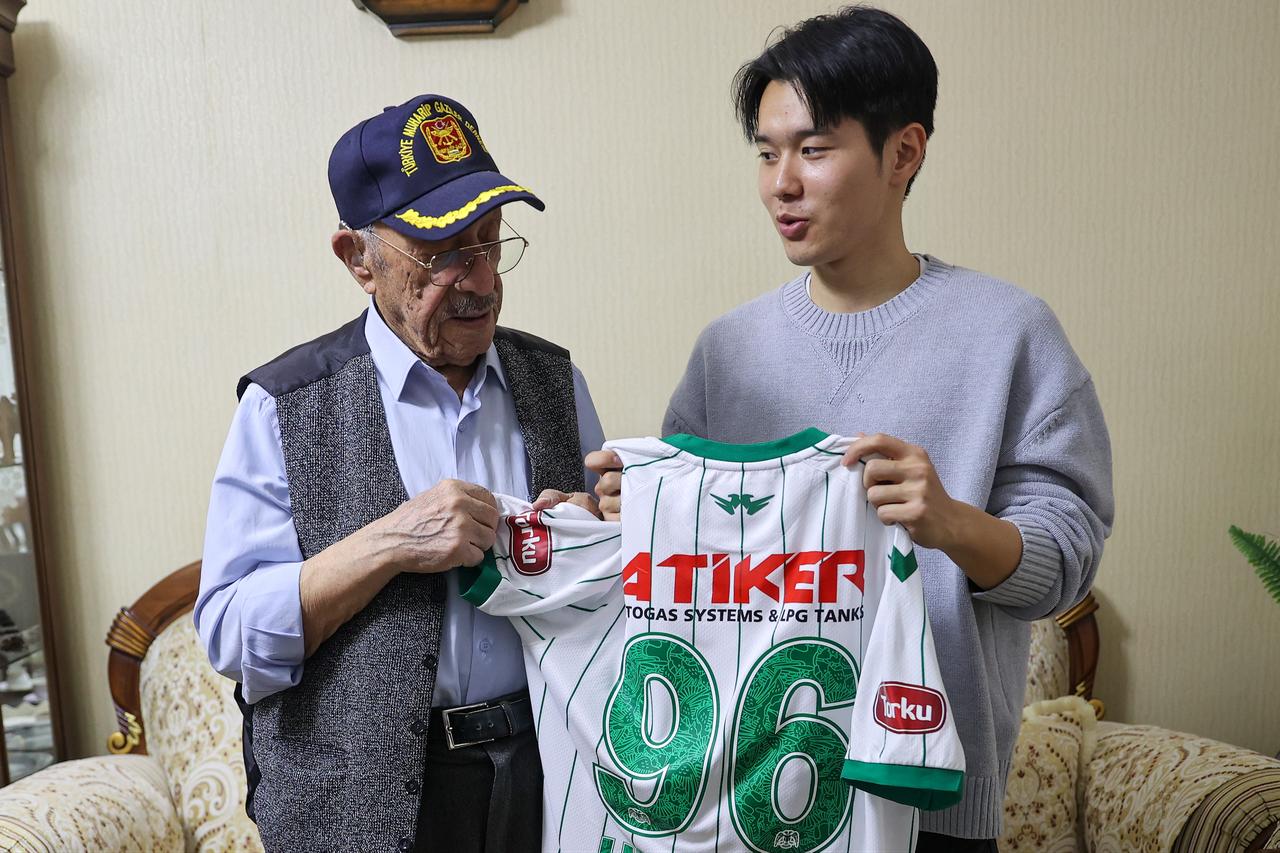 Konyaspor midfielder Jin-ho Jo presents a No. 96 jersey to Korean War veteran Ihsan Damdam during a commemorative visit in Konya, Türkiye, Feb. 13, 2026. (AA Photo)