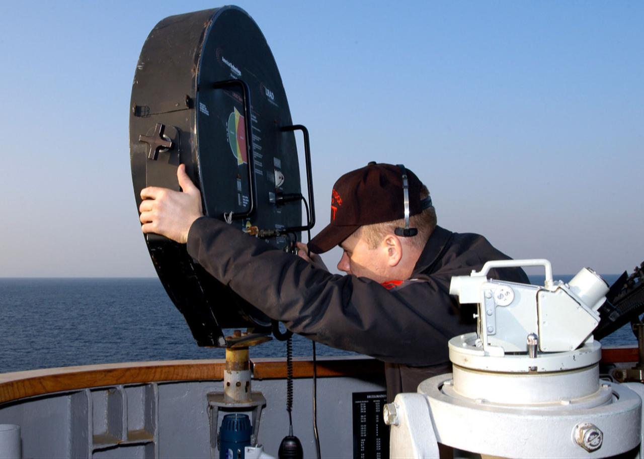 Ship's Serviceman 1st Class Scott D. Amberger aims a Long Range Acoustic Device (LRAD) at an incoming small craft off the starboard bridge wing of amphibious command ship USS Blue Ridge (LCC 19), Jan. 27, 2006. (US Navy Photo)