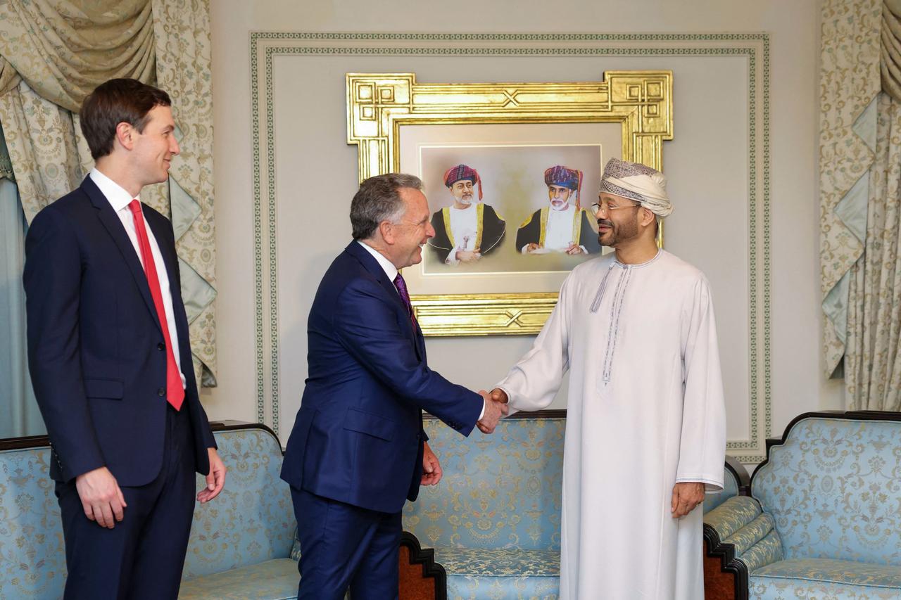 US special envoy Steve Witkoff shakes hands with Oman’s Foreign Minister Badr bin Hamad al-Busaidi as Jared Kushner looks on during a meeting in Muscat, Feb. 6, 2026. (Photo by Handout/Omani Foreign Ministry / AFP)