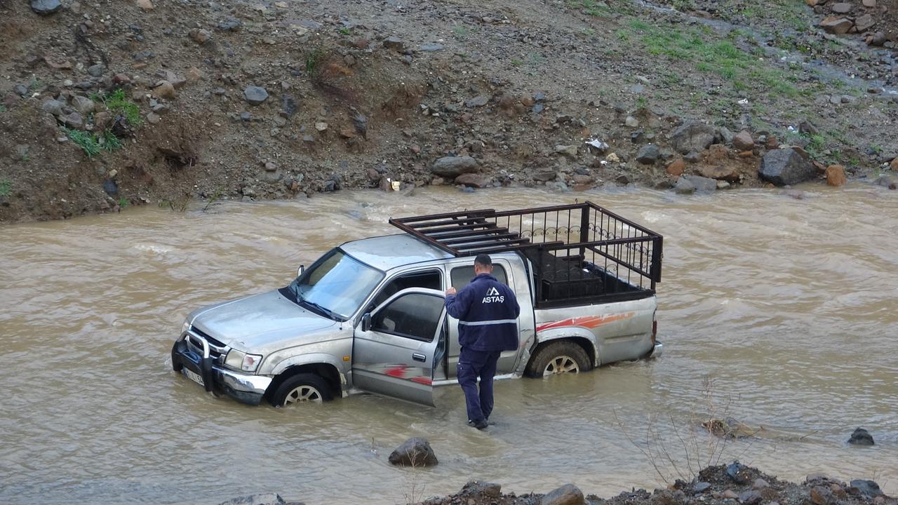 A man attempts to get into vehicle as floodwaters rise in Antakya, Hatay, Türkiye. (IHA Photo)