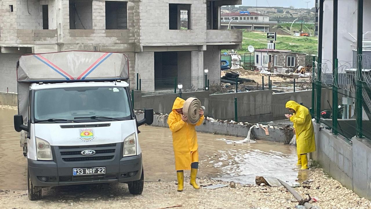Municipal workers carry equipment through floodwaters after heavy rainfall in Tarsus, Mersin, Türkiye. (IHA Photo)