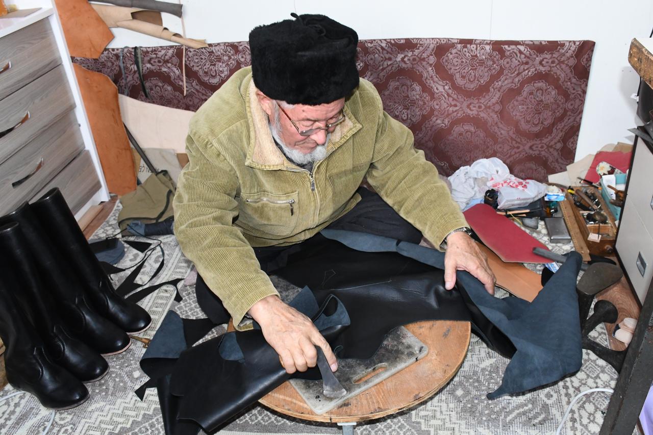 A Kyrgyz leather artisan works by hand on traditional footwear in Yenifakili district of Yozgat, central Türkiye, Feb. 15, 2026. (IHA Photo)