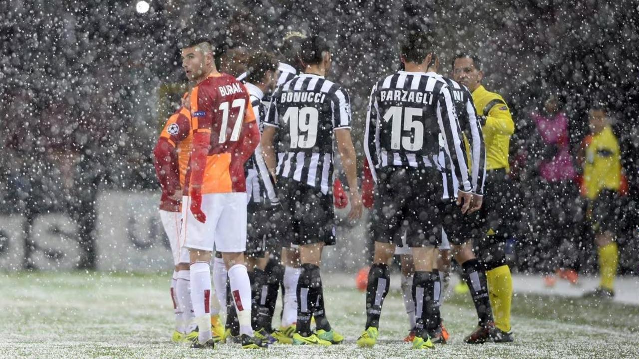 Galatasaray and Juventus players gather around referee Pedro Proenca as heavy snowfall forces the UEFA Champions League match in Istanbul to be abandoned on Dec. 10, 2013. (AFP Photo)