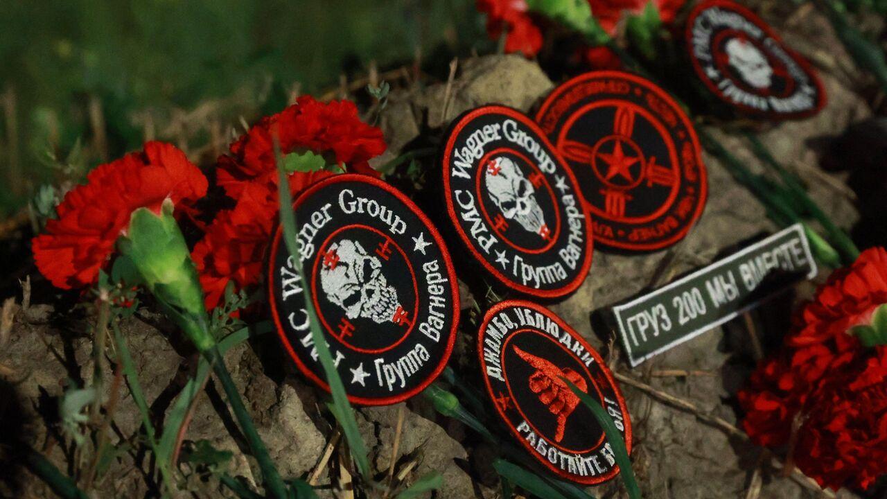 Flowers and patches bearing the logo of private mercenary group Wagner are seen at a makeshift memorial in front of the "PMC Wagner Centre" in Saint Petersburg, early, August 24, 2023. (AFP Photo)
