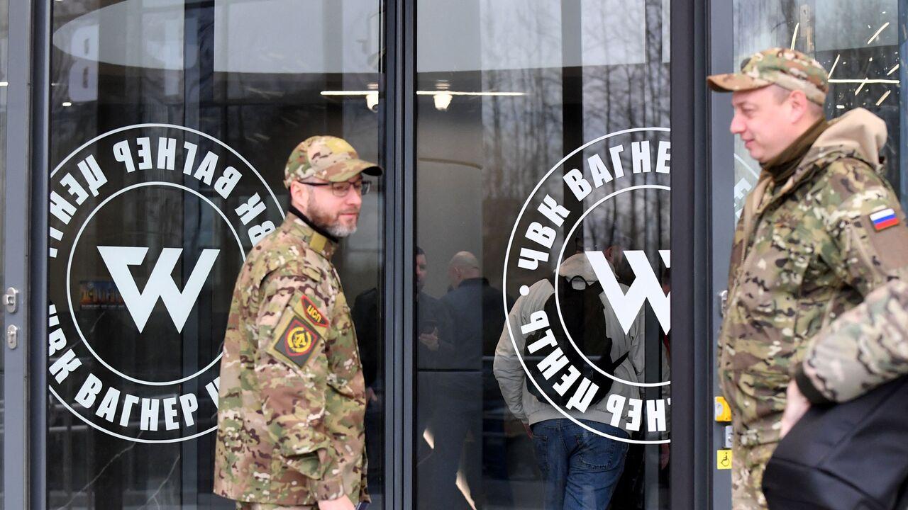 Visitors wearing military camouflage stand at the entrance to the 'PMC Wagner Centre', associated with the founder of the Wagner private military group (PMC), in Saint Petersburg, Nov. 4, 2022. (AFP Photo)