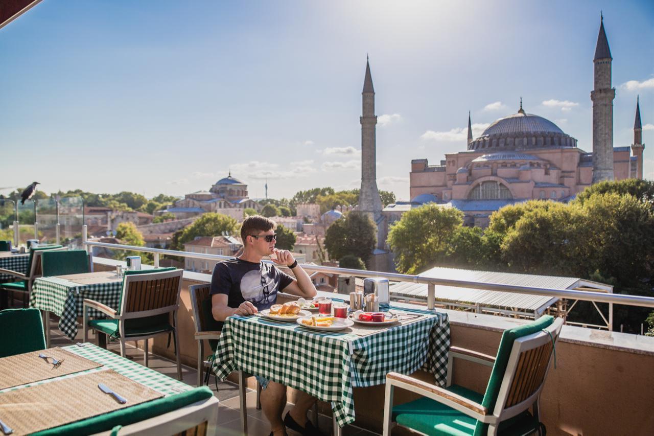 A man has breakfast at a restaurant with a view of the Hagia Sophia in Istanbul, Türkiye. (Adobe Stock Photo)