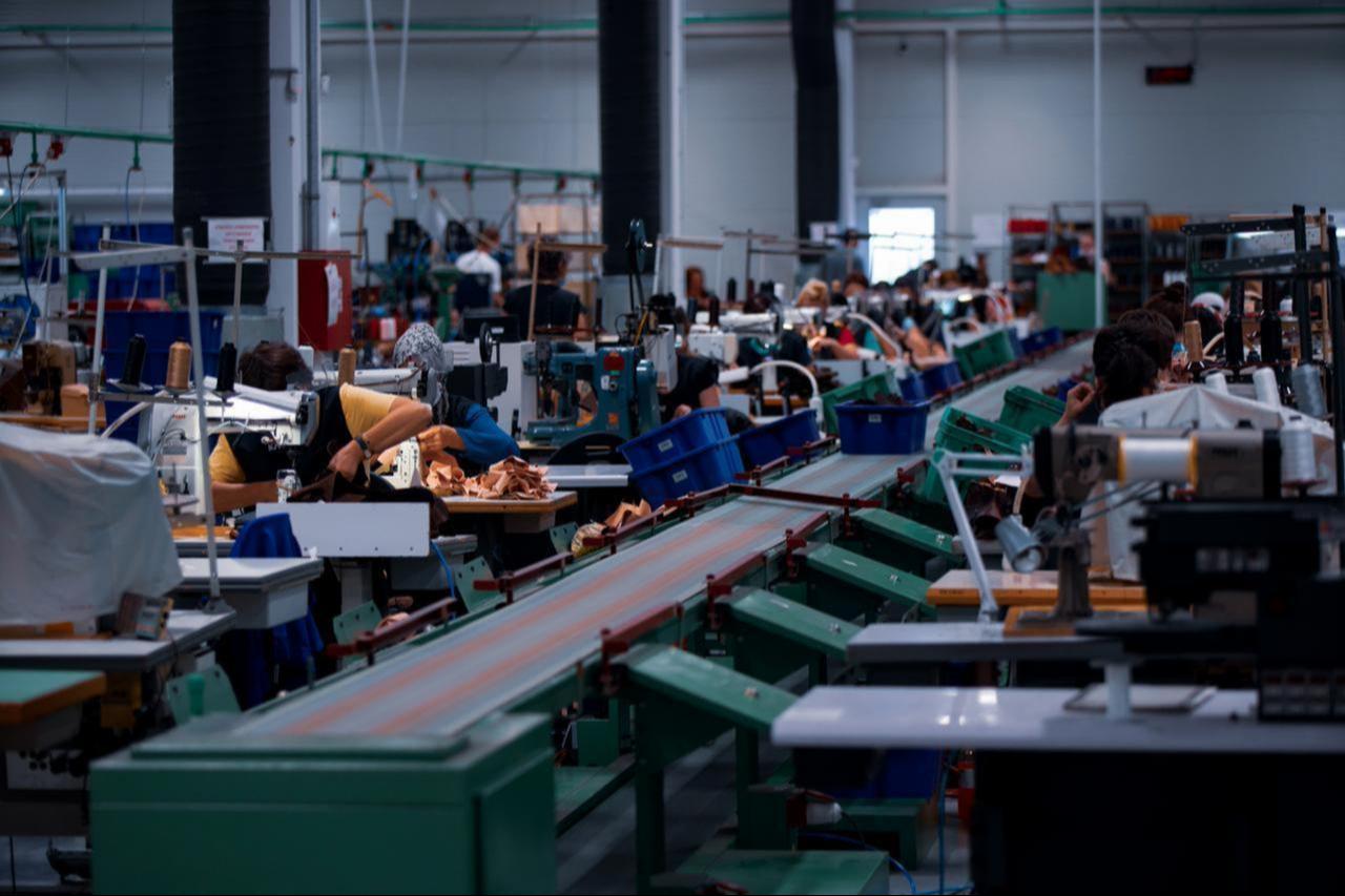 Workers operate sewing machines in a textile manufacturing facility. (Adobe Stock Photo)